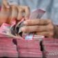 Karyawan menghitung uang pecahan rupiah di salah satu gerai penukaran mata uang asing di Jakarta, Senin (27/7/2026). (Foto: ANTARA FOTO/Rivan Awal Lingga)