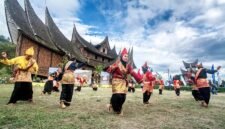 Pentas seni tradisional randai Minangkabau di lapangan dengan rumah adat beratap gonjong di belakangnya. (Foto: Dok. Wikimedia Commons/Deni Dahniel (CC BY-SA 4.0))